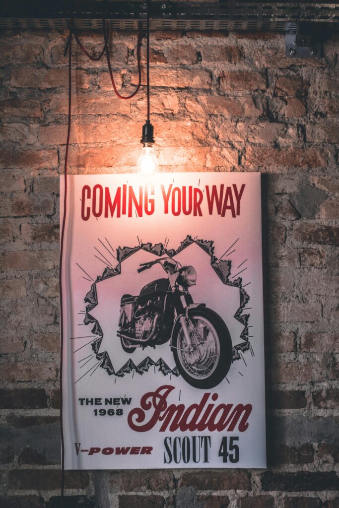pexels-photo-331987-331987 Retro 1968 Indian Scout 45 motorcycle poster with vintage bulb against brick wall.